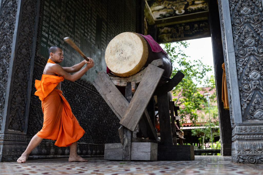Monk hitting the Drum before the prayer
