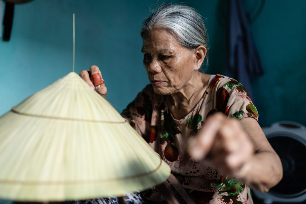 Vietnamese woman making conical hat