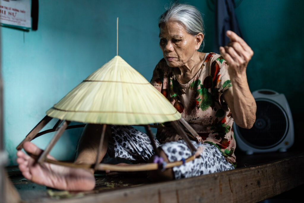 Vietnamese woman making conical hat